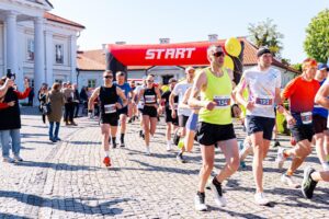 Uczestnicy biegu Akademicka Dycha wybiegają z miejsca startu pod Pałacem Ogińskich.