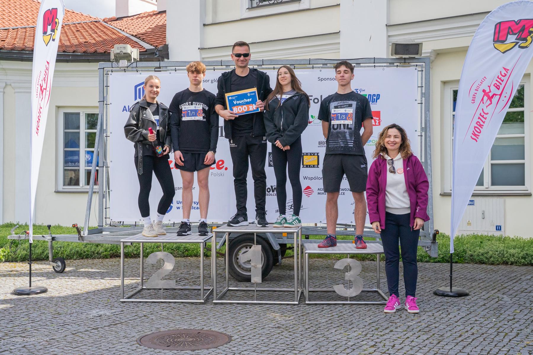 Wygrani sztafety pozuja na podium.